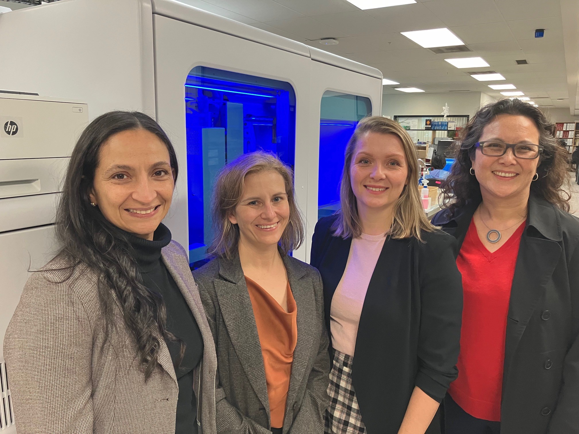 Four public health professionals stand smiling side by side